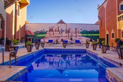 a pool in front of a building with a mural at lmtounipalace in Ouarzazate