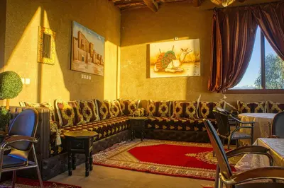 a living room with a couch and tables and chairs at lmtounipalace in Ouarzazate