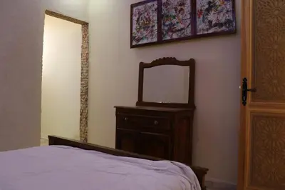 a bedroom with a bed and a mirror on a dresser at Dar margoum in Marrakech