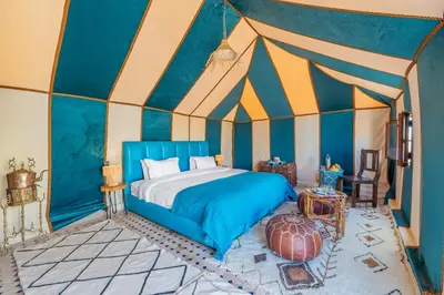 a bedroom with a bed in a tent at Sahara Magic Luxury Camp & Camel trek in Merzouga