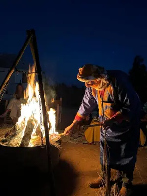 a man standing in front of a fire at Sahara Magic Luxury Camp & Camel trek in Merzouga