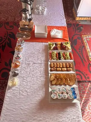 a table with three trays of different types of food at La Sultana Luxury Camp in Merzouga