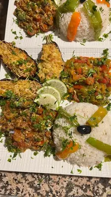 a plate of food with rice and meat and vegetables at La Sultana Luxury Camp in Merzouga