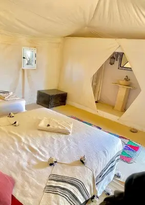 a bedroom with a bed in a tent at Merzouga Luxurious Camp in Merzouga