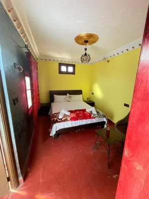 a bedroom with a bed in a room with yellow walls at Dar Boujloud Fez in Fès