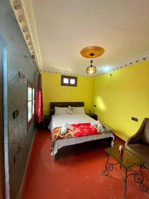 a bedroom with a bed in a yellow room at Dar Boujloud Fez in Fès