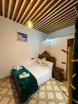 a bedroom with a bed with two towels on it at Dar Boujloud Fez in Fès