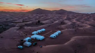 a group of blue tents in the desert at Sultan's Sinbad Luxury Camp in Merzouga