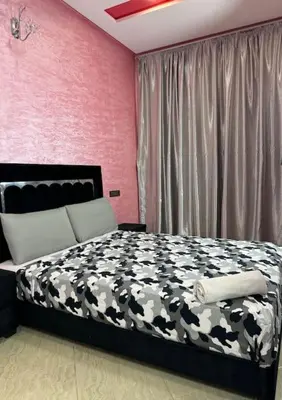 a bedroom with a black and white bed and pink walls at Appartement fes centre in Fès