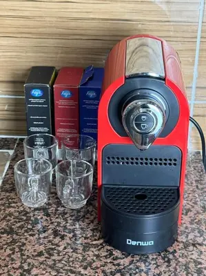 a red blender sitting on a counter with glasses at Appartement fes centre in Fès