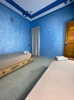 a room with a bed in a room with blue walls at Appartement fes centre in Fès