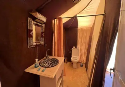 a small bathroom with a sink and a toilet at White Camp Desert Safari in Merzouga