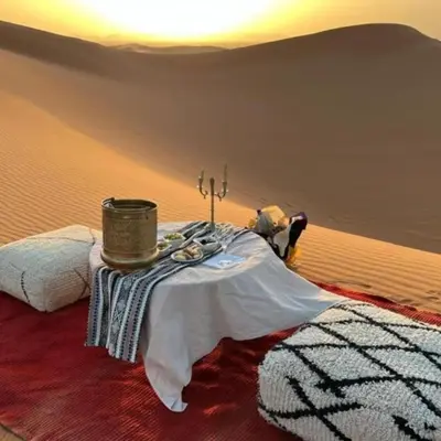 a room with a table in the middle of a desert at White Camp Desert Safari in Merzouga