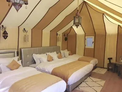 a room with three beds in a room with a ceiling at White Camp Desert Safari in Merzouga