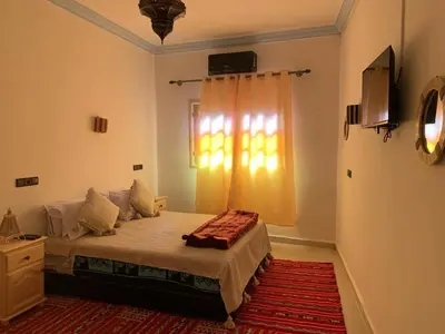 a bedroom with a large bed and a window at Dar Ayour Todra Gorges in Aït Baha