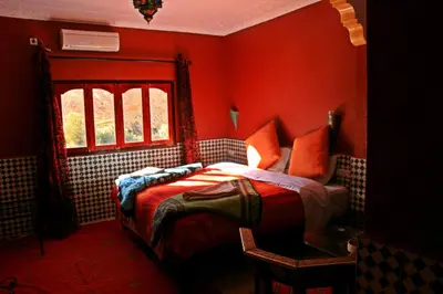 a red bedroom with a bed and a window at Dar Ayour Todra Gorges in Aït Baha