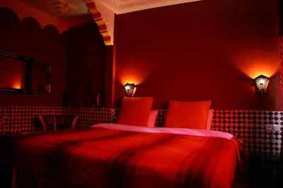 a red bedroom with a bed and two lights at Dar Ayour Todra Gorges in Aït Baha