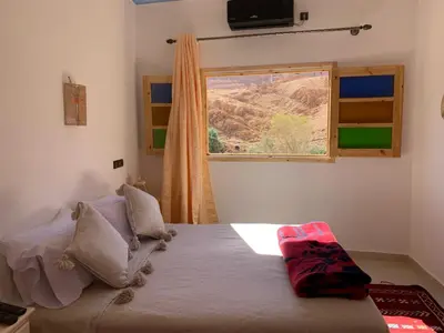 a bedroom with a bed and a window with a view at Dar Ayour Todra Gorges in Aït Baha