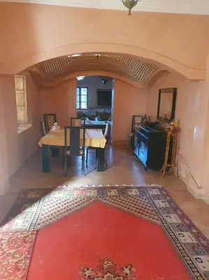 a living room with a table and a red rug at John's Place in Marrakech
