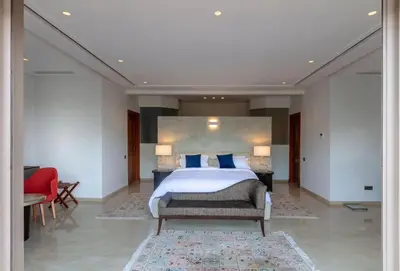 a bedroom with a large bed with blue pillows at Villa Lamaan - Domaine prive piscine et hammam in Douar bel Rhanodour