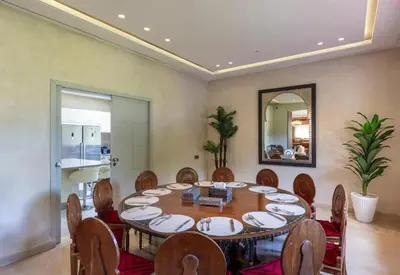 a dining room with a table and chairs and a mirror at Villa Lamaan - Domaine prive piscine et hammam in Douar bel Rhanodour