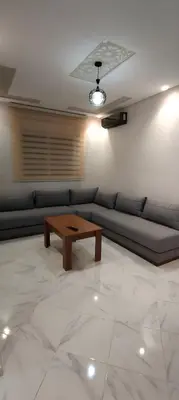 a living room with a couch and a coffee table at Superbe appartement à Meknes in Meknès