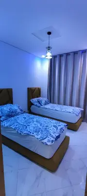 two beds in a room with a blue light at Superbe appartement à Meknes in Meknès