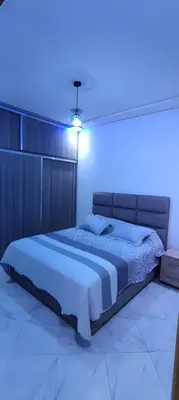 a bedroom with a large bed with a blue light at Superbe appartement à Meknes in Meknès