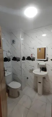 a white bathroom with a toilet and a sink at Superbe appartement à Meknes in Meknès
