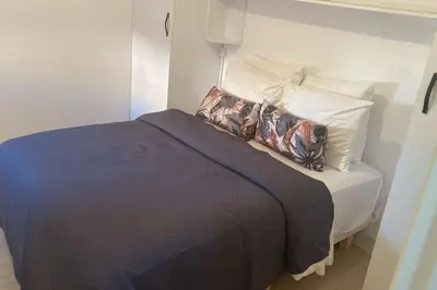 a bedroom with a bed with a blue blanket and pillows at Appartement équipé! in Ouarzazate