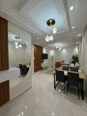 a dining room with a table and chairs and a tv at Appartement Moderne in Meknès