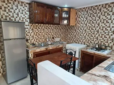 a kitchen with a white refrigerator and a table at The Orchard Cozy & Comfy Apartment 1 in Ifrane