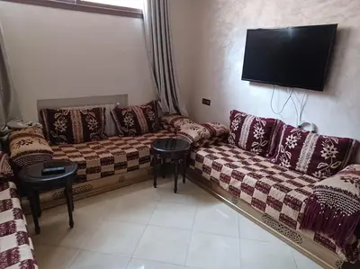 a living room with a couch and a flat screen tv at The Orchard Cozy & Comfy Apartment 1 in Ifrane