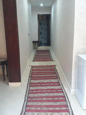 a hallway with a red and white rug on the floor at The Orchard Cozy & Comfy Apartment 1 in Ifrane