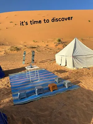 a tent and a table in the middle of the desert at Time to Discover Wild Camp in Merzouga
