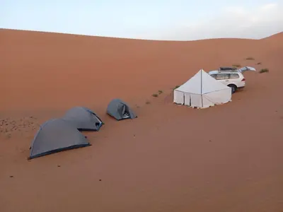 a group of tents and a car in the desert at Time to Discover Wild Camp in Merzouga