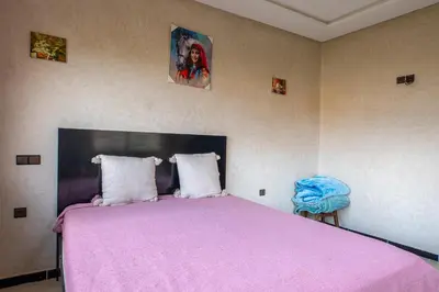 a bedroom with a large bed with a pink blanket at Bab Alas apartments N2 in Ourika valley in Ourika