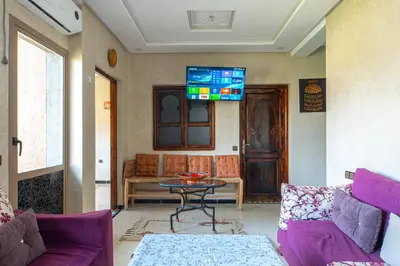 a living room with purple furniture and a tv on the wall at Bab Alas apartments N2 in Ourika valley in Ourika