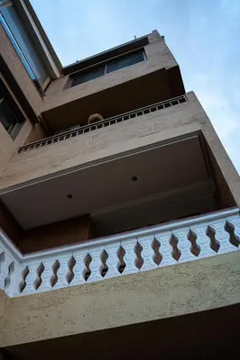 a building with a balcony with a dog sitting on it at Bab Alas apartments N2 in Ourika valley in Ourika