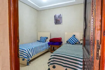 a bedroom with two beds with blue and white stripes at Bab Alas apartments N2 in Ourika valley in Ourika