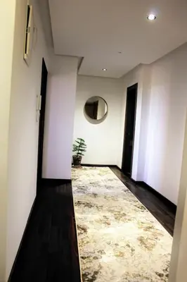 a hallway with white walls and a rug at شقق الاسد افران in Ifrane