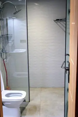 a bathroom with a toilet and a glass shower at شقق الاسد افران in Ifrane