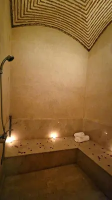 a bathroom with a tub with a towel and lights at Villa Alcázar Marrakech in Had Abdallah Rhiat