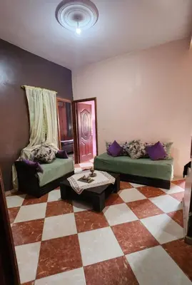 a living room with two beds and a checkered floor at residence kawtar in Meknès