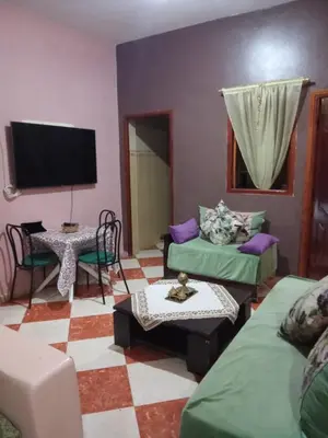 a living room with two beds and a flat screen tv at residence kawtar in Meknès