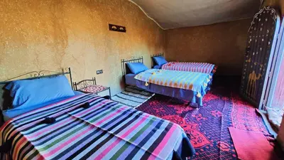 a room with two beds in a room at Nomads Heaven Camp in Mhamid