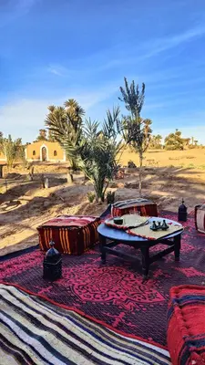 a pool table sitting on a rug in the desert at Nomads Heaven Camp in Mhamid