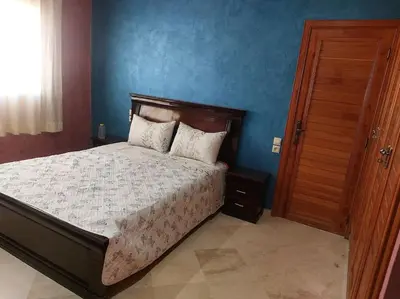 a bedroom with a bed and a blue wall at séjour confort et design à Fès in Fès
