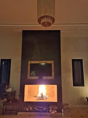 a fireplace in a living room with a fire at Villa Rahma in Marrakech