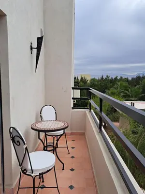 a balcony with two chairs and a table and a view at Villa Rahma in Marrakech